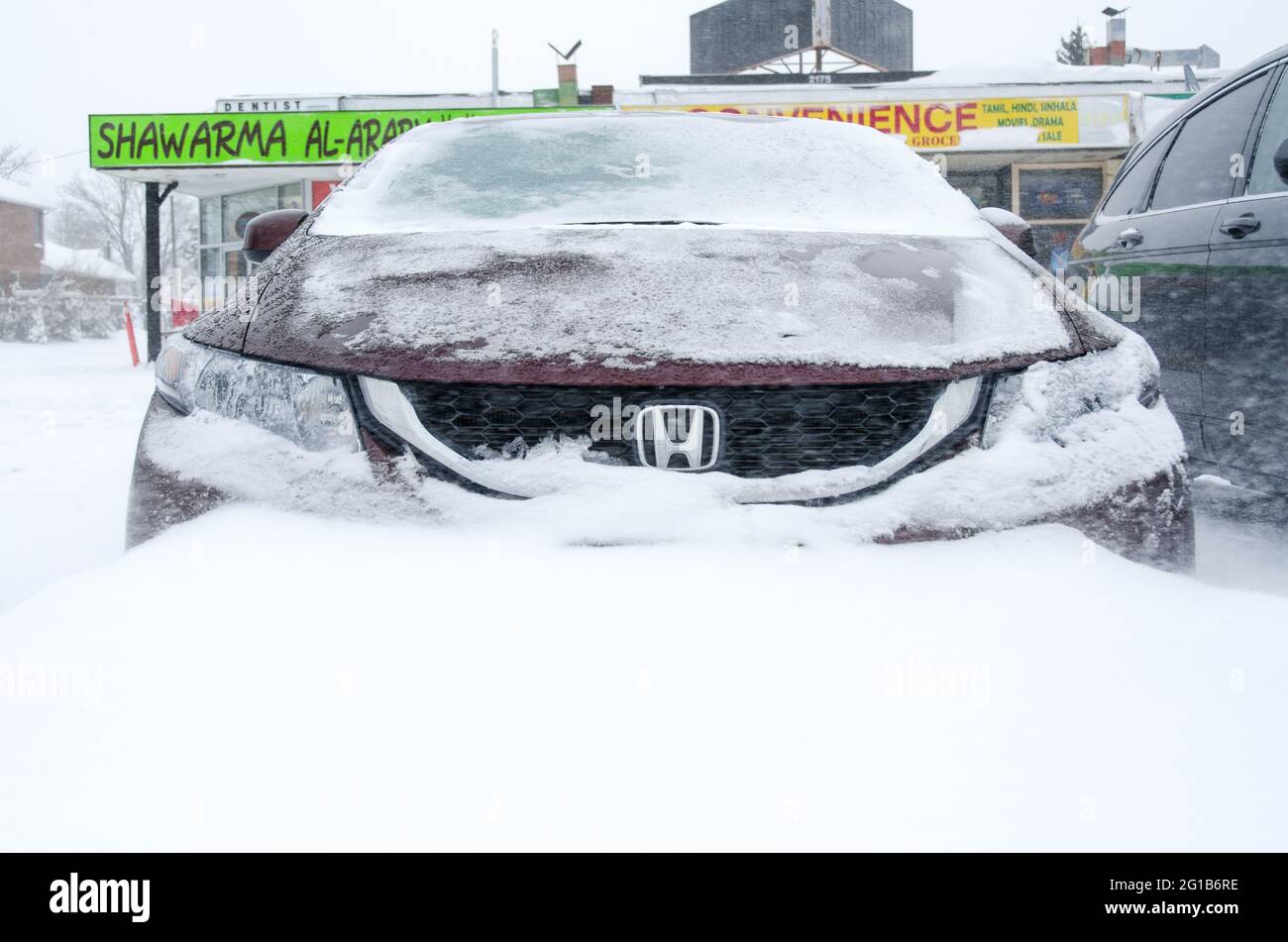 Car covered in snow during the harsh Winter that hit Toronto during the superstorm or polar vortex of 2014. Stock Photo