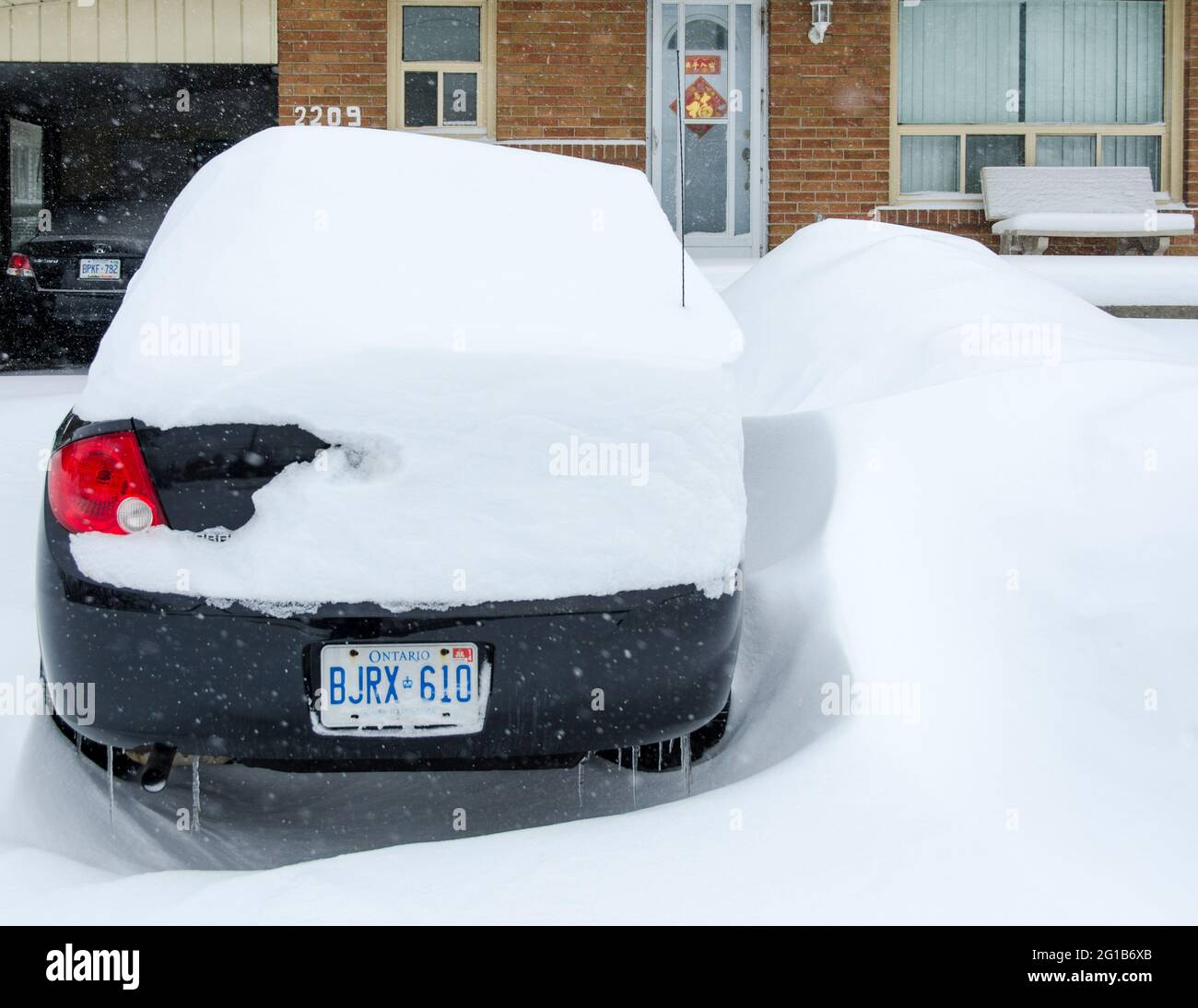 Car covered in snow during the harsh Winter that hit Toronto during the superstorm or polar vortex of 2014. Stock Photo