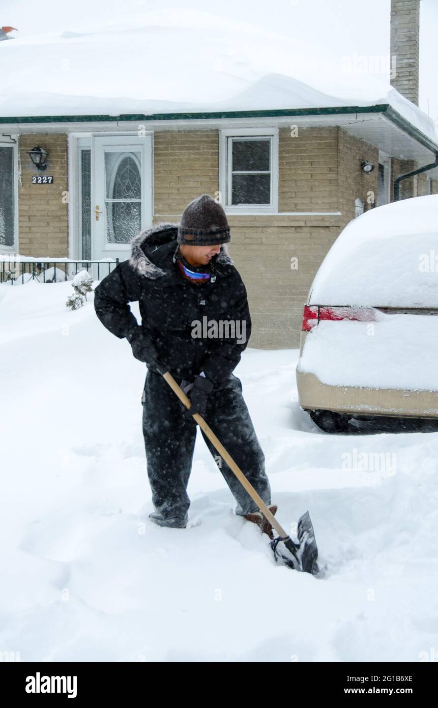 Person clearing the driveway during the superstorm or polar vortex that hit Toronto in 2014 producing a very harsh Winter. Stock Photo