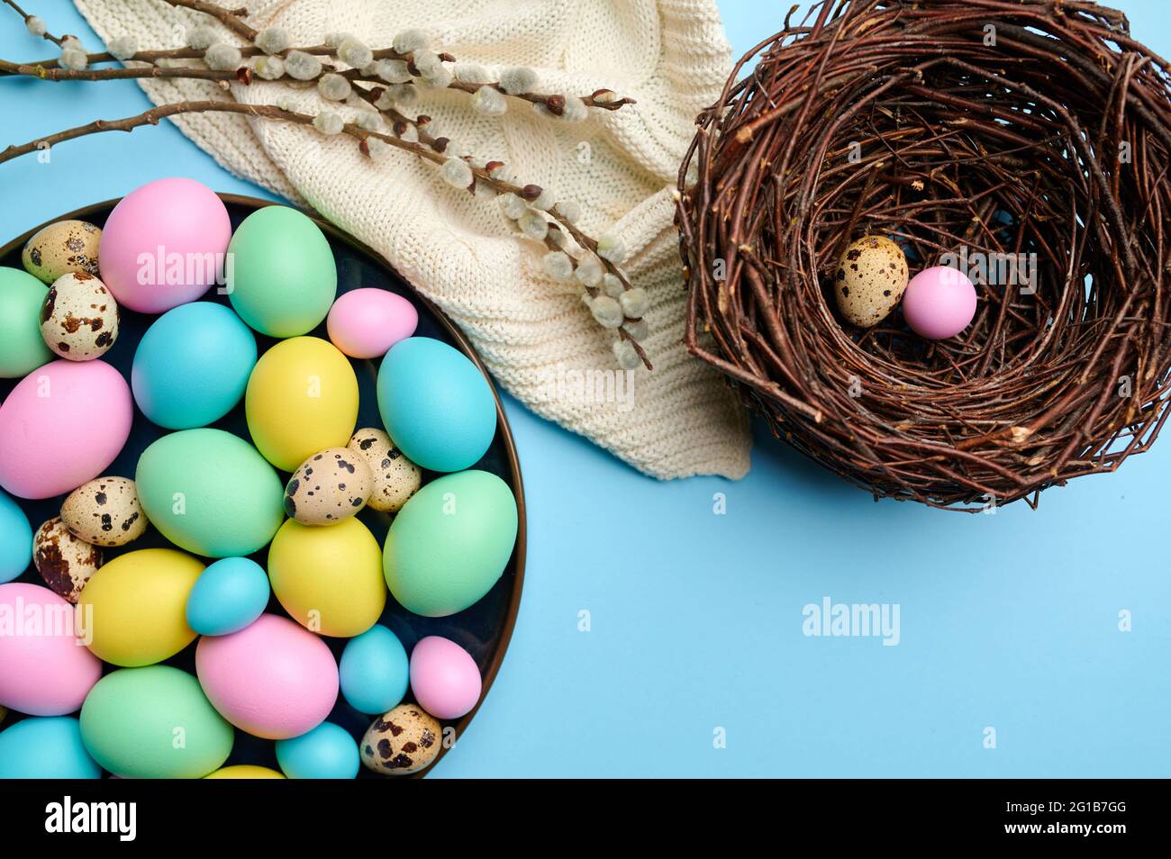 Colorful easter eggs in bowl and decorative nest Stock Photo