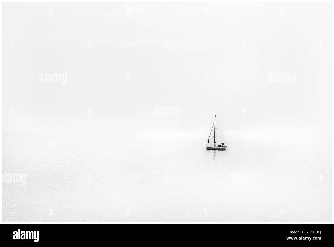 Sailboat at sea on calm day serenity tranquil peaceful Stock Photo
