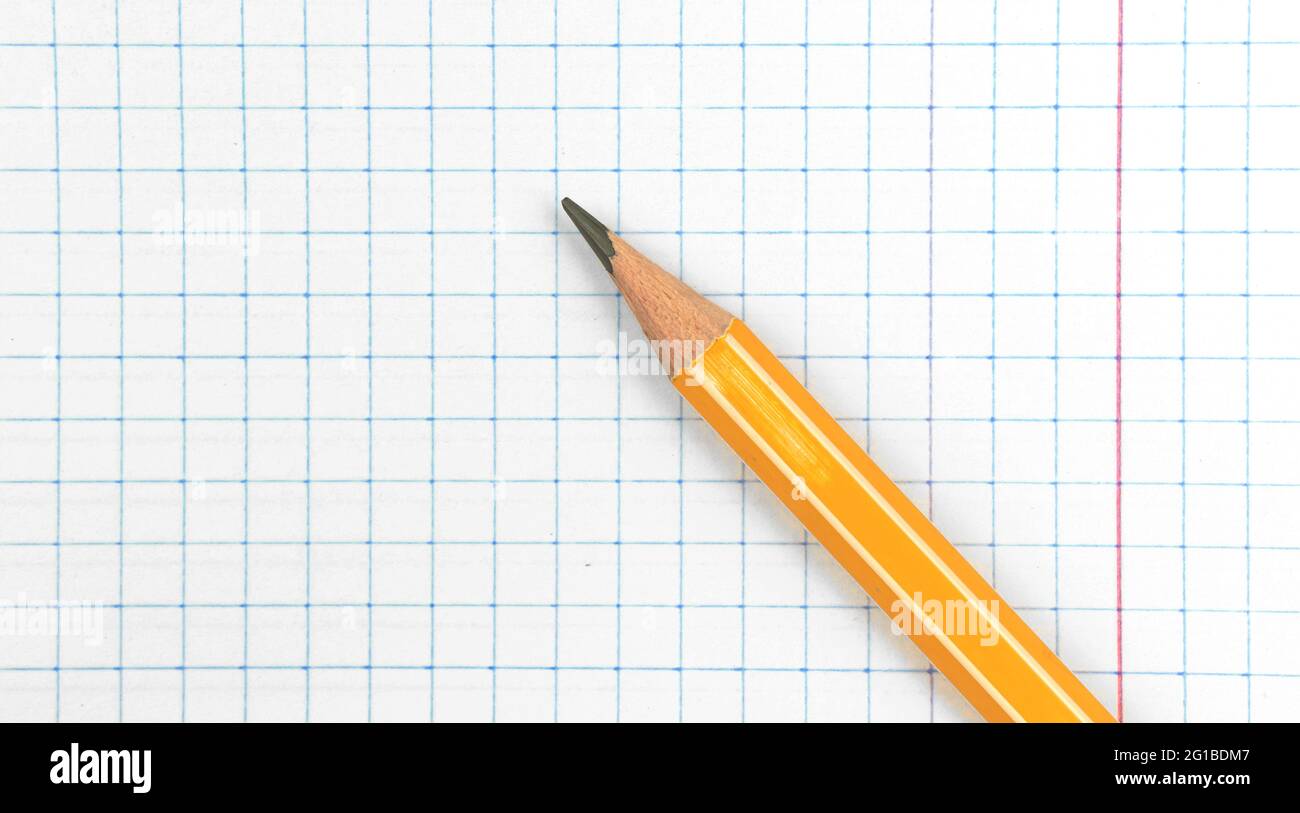 Sharp lead pencil school stationery on a checkered notebook background, close-up with copy space, top view Stock Photo