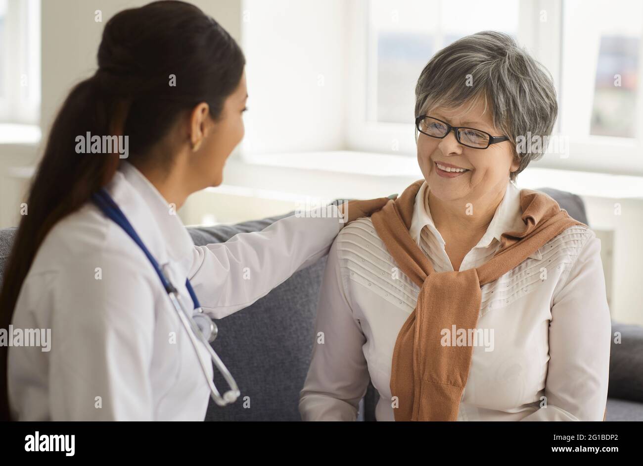 Female doctor consulting senior patient at private clinic closeup portrait Stock Photo