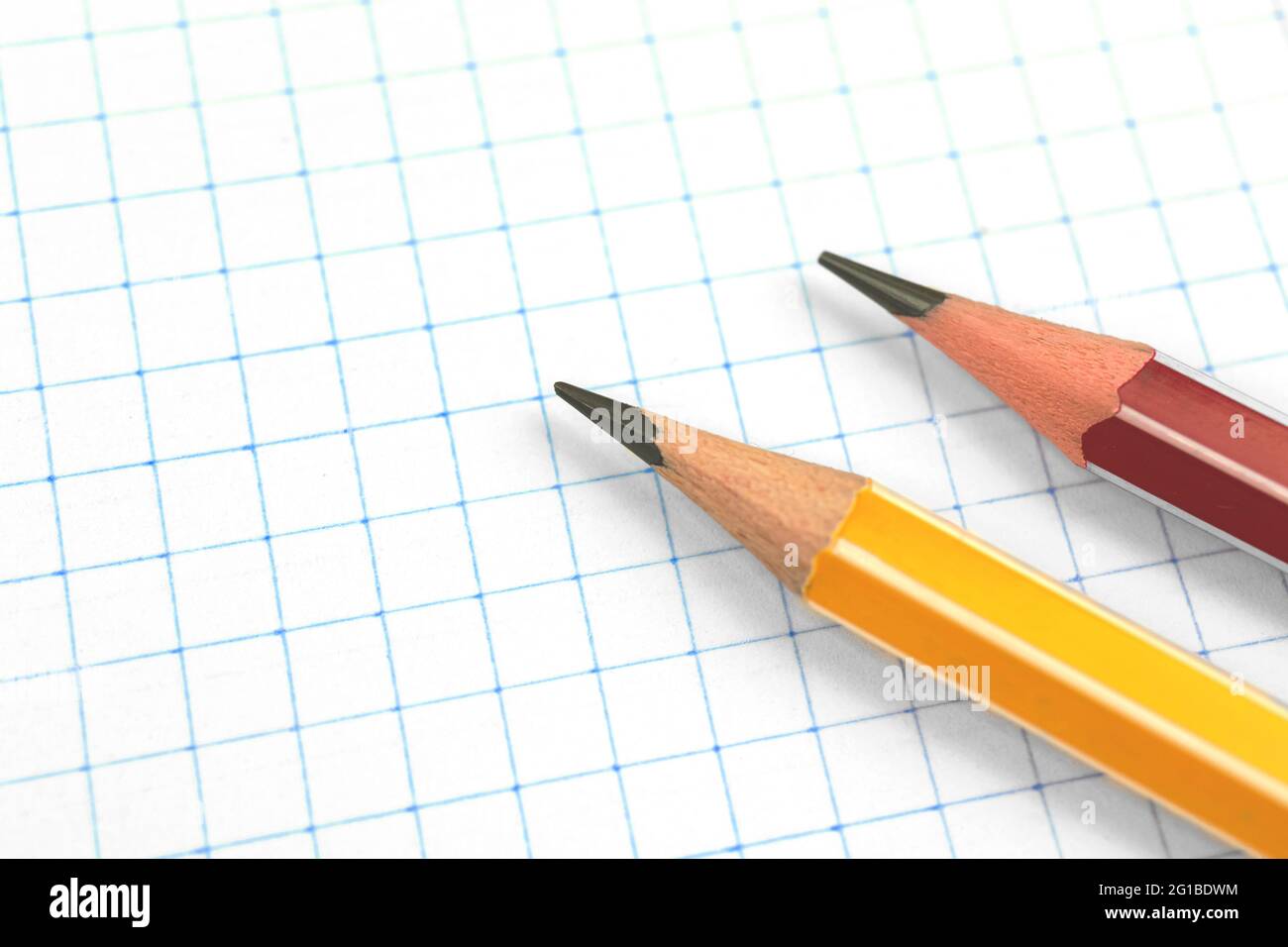 Lead pencils on a checkered notebook page background, education concept, copy space Stock Photo