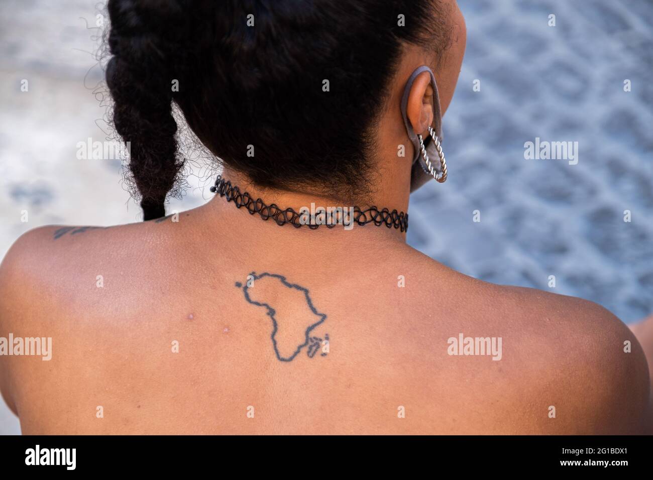 Barcelona, Spain. 06th June, 2021. A protester with a tattoo on her back representing the African continent during the demonstration. Summoned by Black Community Resists, a group of people have gathered in Plaza de Sant Jaume to commemorate the year of the murderer of the American citizen, George Floyd and denounce systemic and structural racism. Credit: SOPA Images Limited/Alamy Live News Stock Photo