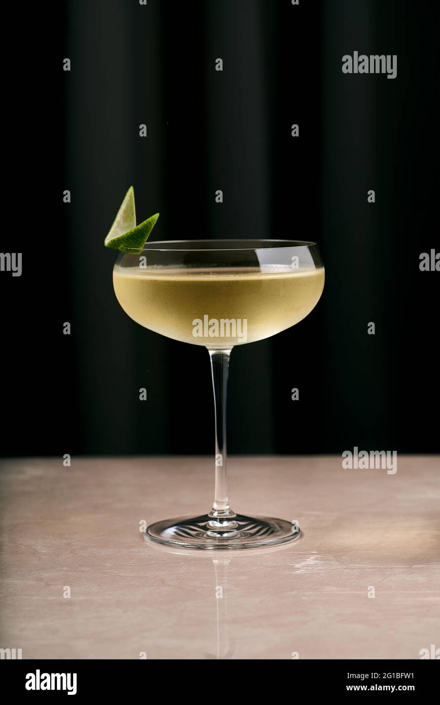 Elegant crystal coupe glass of champagne cocktail decorated with lime