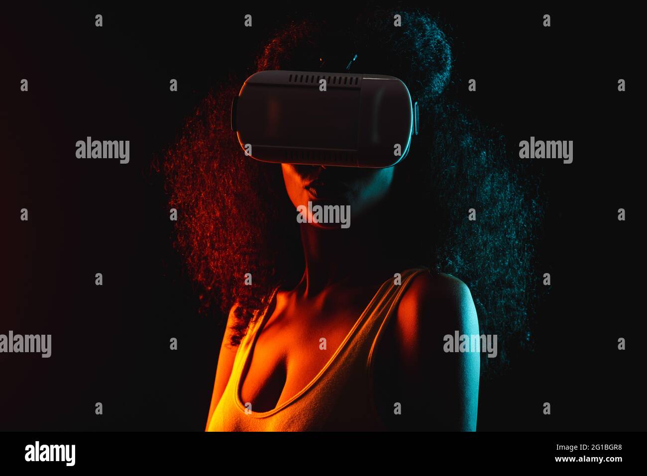 Anonymous ethnic female exploring virtual reality in headset on black background Stock Photo