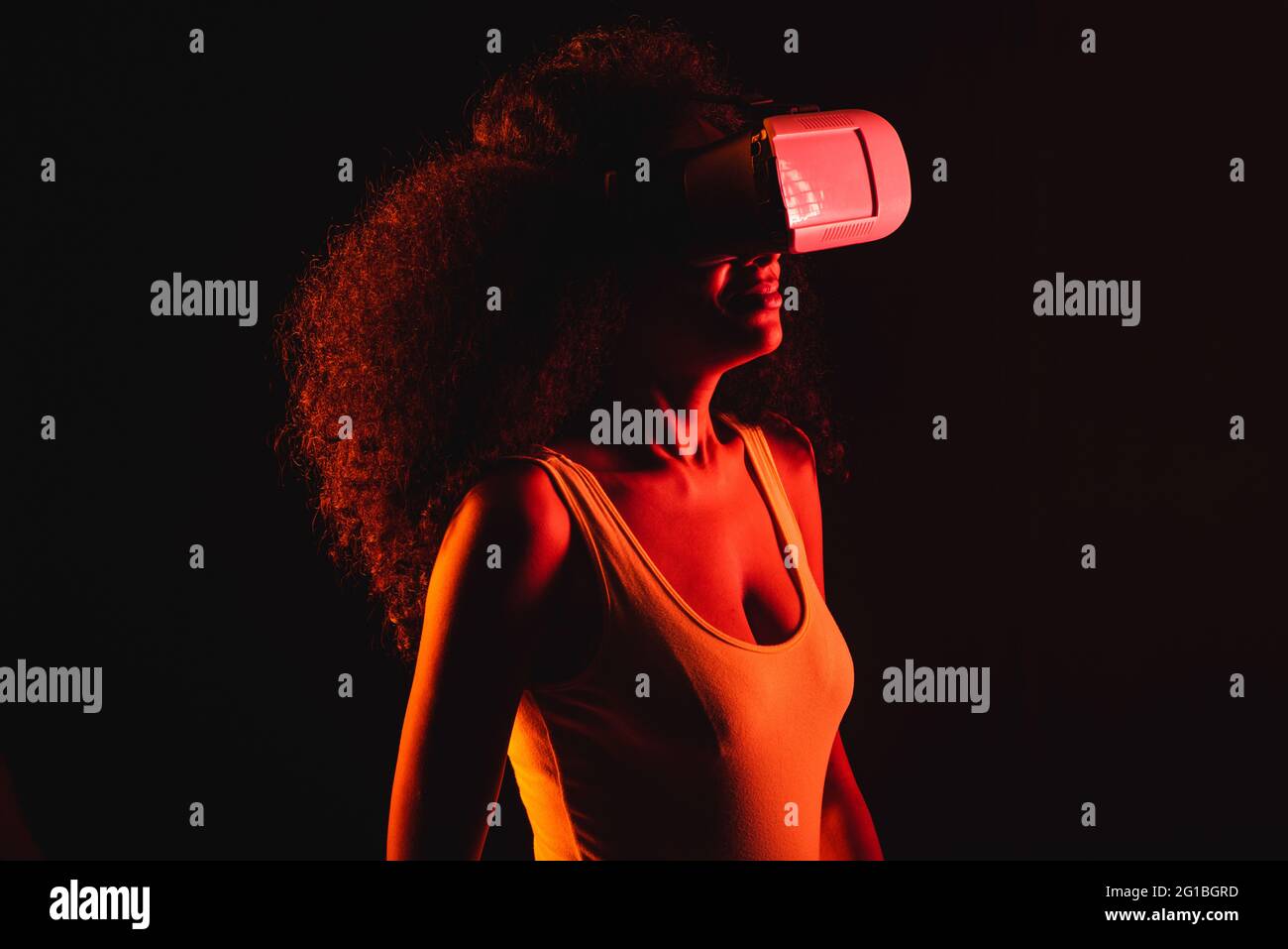 Anonymous ethnic female exploring virtual reality in headset on black background Stock Photo