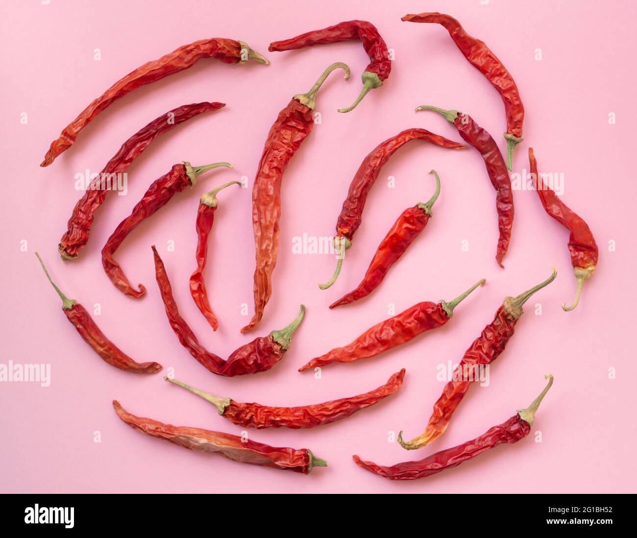 Flat lay dried red chili peppers pattern on a pink color background ...