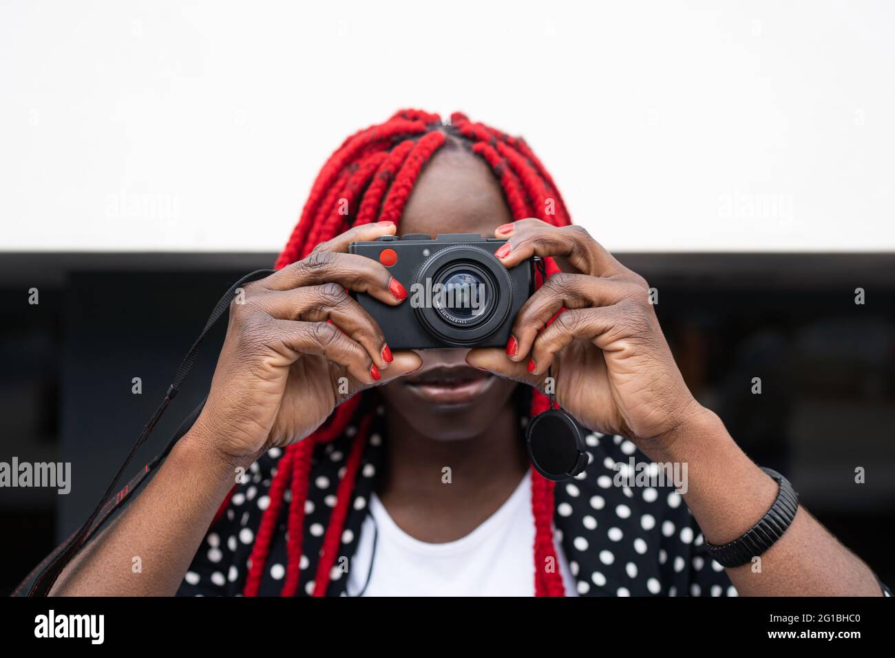 African American with red hair taking picture on photo camera Stock Photo