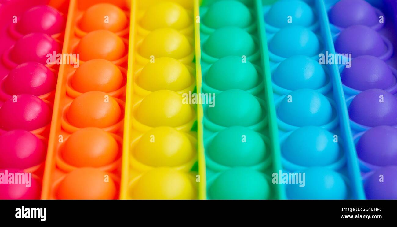 Close up.a new sensory toy - pop it, antistress concept.Rainbow color, convex bubbles Stock Photo