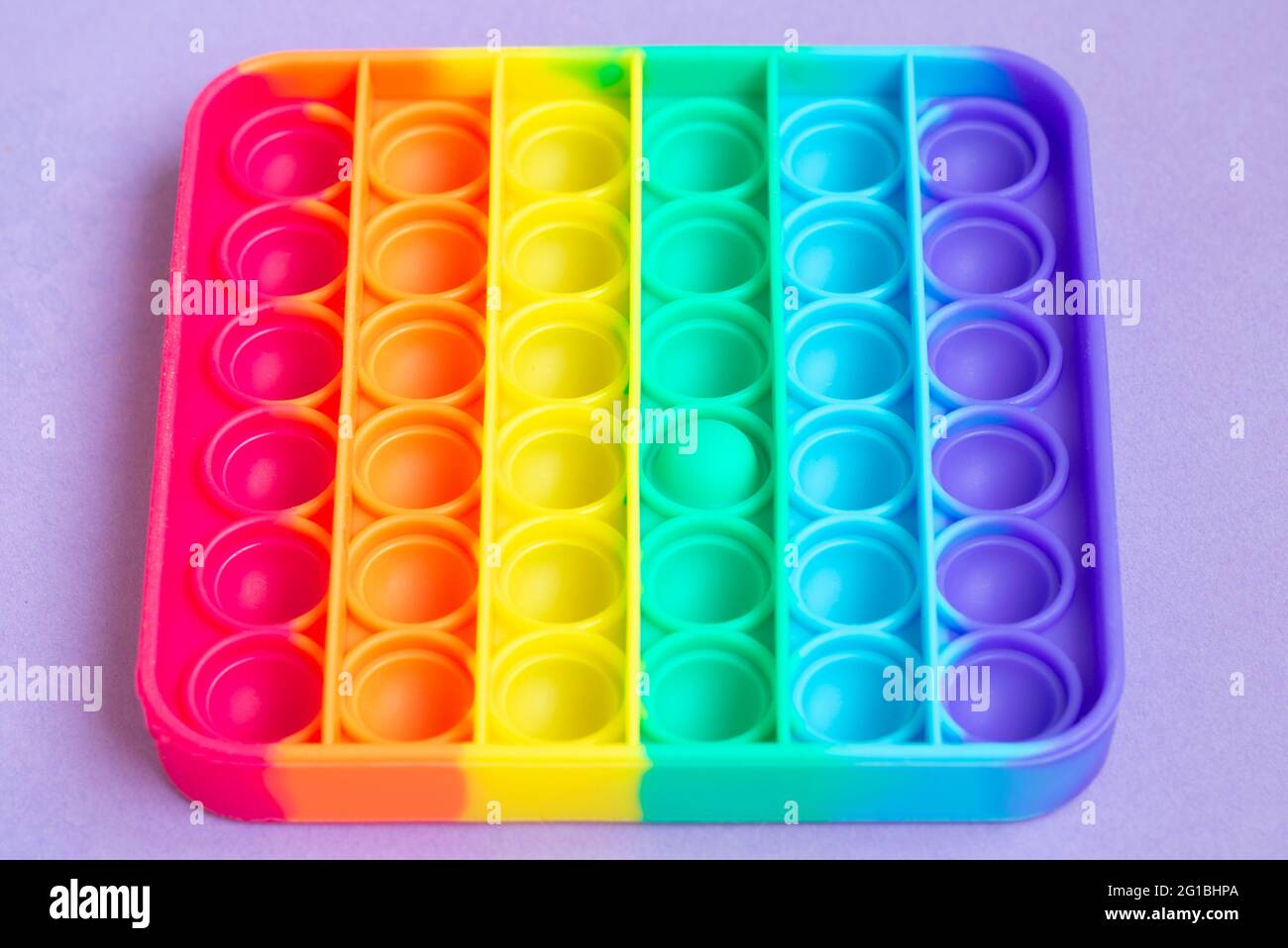 new sensory toy - pop it, antistress concept.Rainbow color, concave and convex bubbles.Close up.Top view. Stock Photo