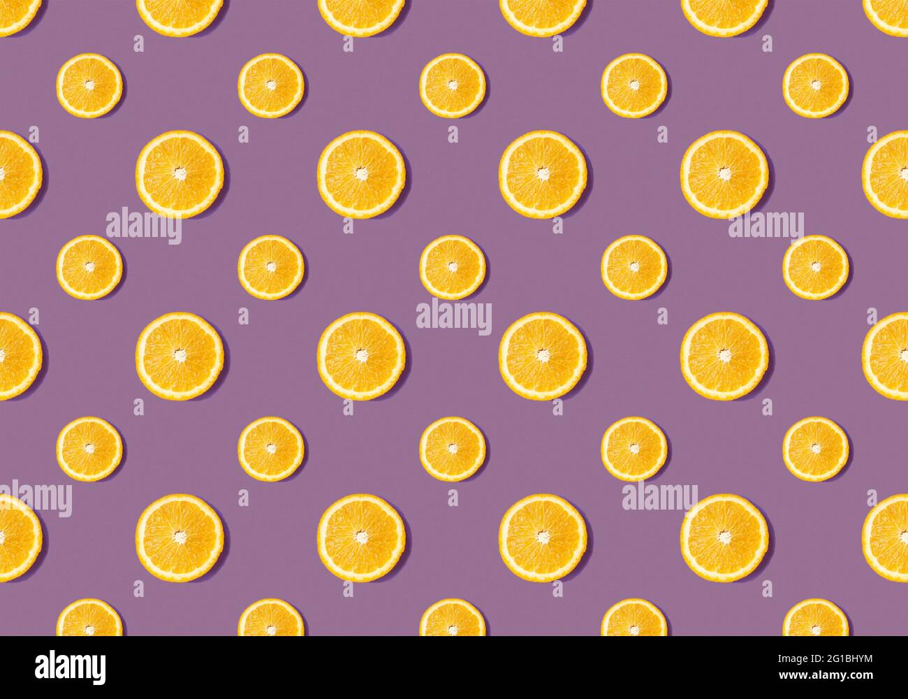 Fruit pattern from slices of orange on purple background. Flat lay Stock Photo