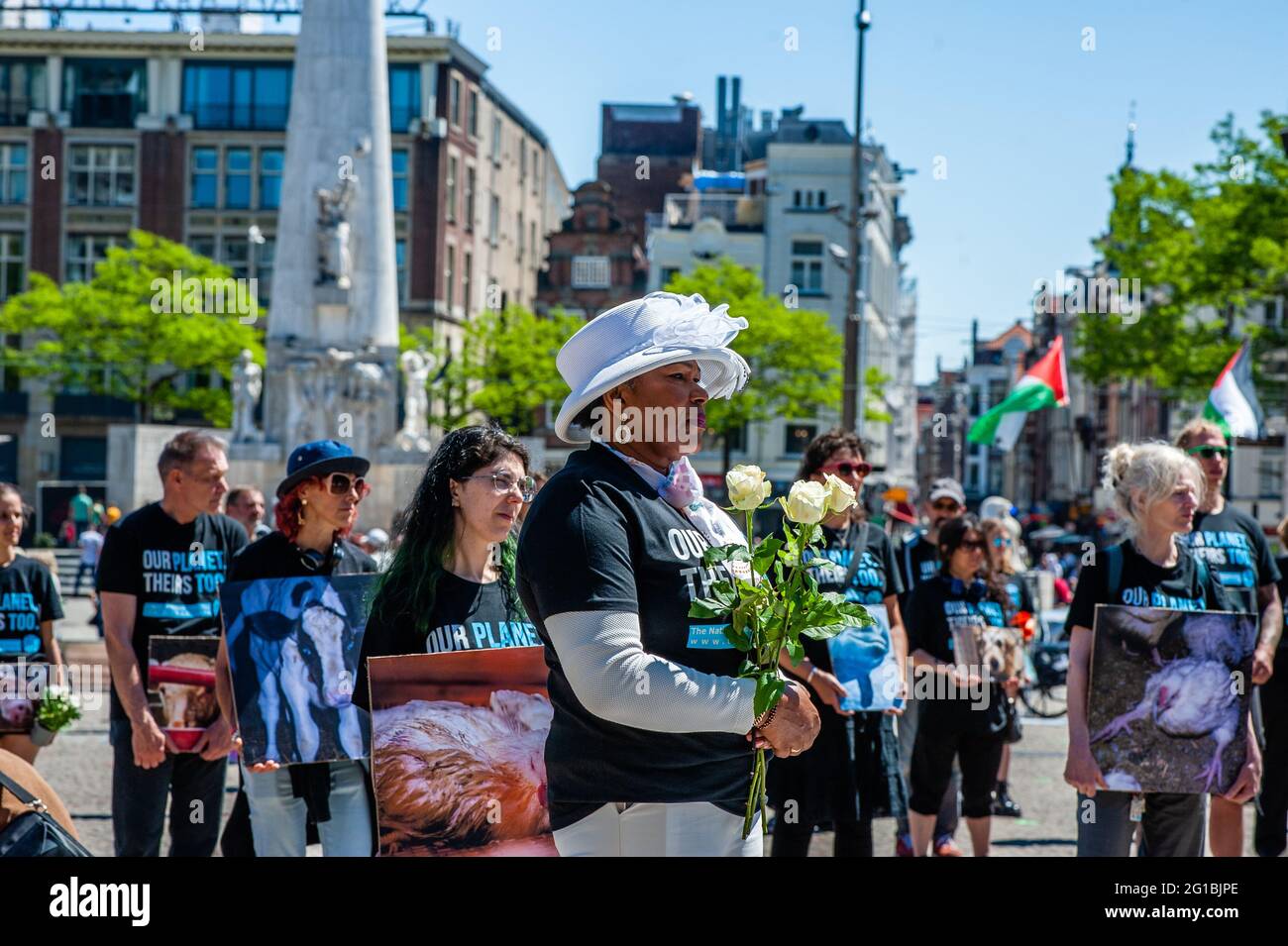 Amsterdam, Netherlands. 06th June, 2021. A woman holds a bunch of white  roses as she listens to a speech during the animal memorial day in   Amsterdam, hundreds of animal activists gathered