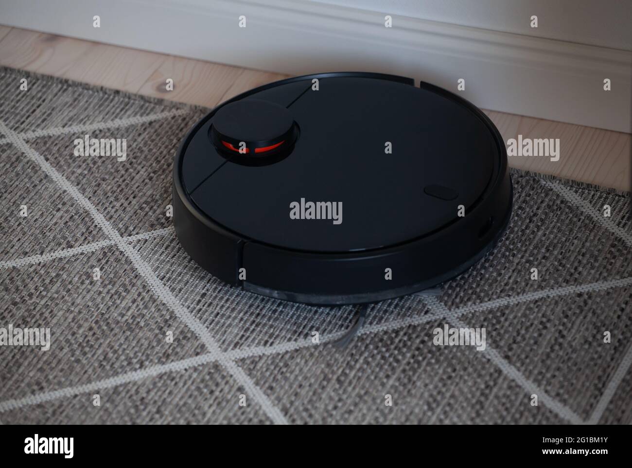 Robotic vacuum cleaner cleaning carpet at home Stock Photo Alamy