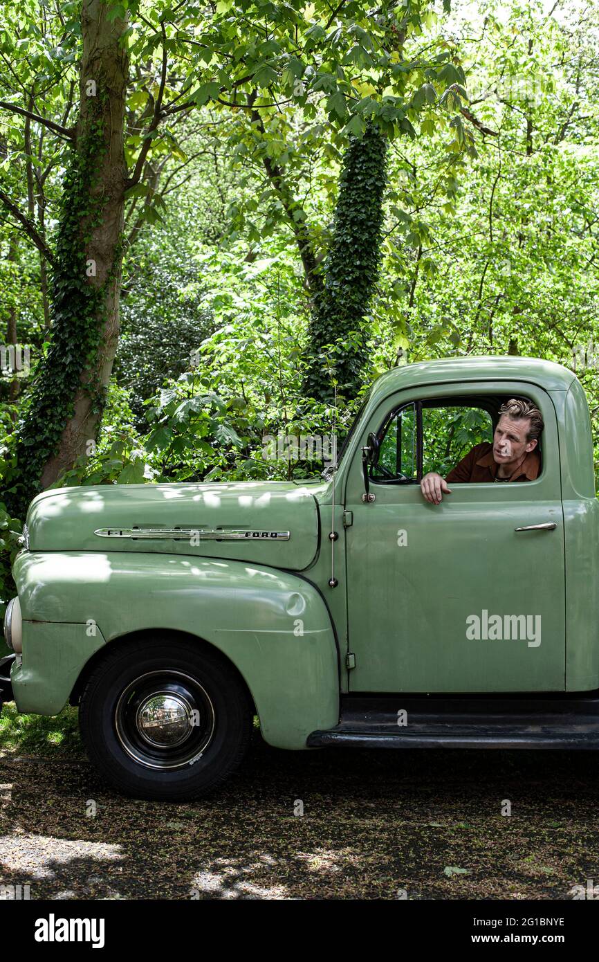 Man sitting inside his Ford F 1 pick-up truck. Stock Photo