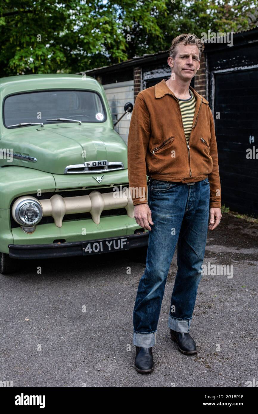 Man wearing jeans standing in fron of  his Ford F 1 pick-up truck. Stock Photo