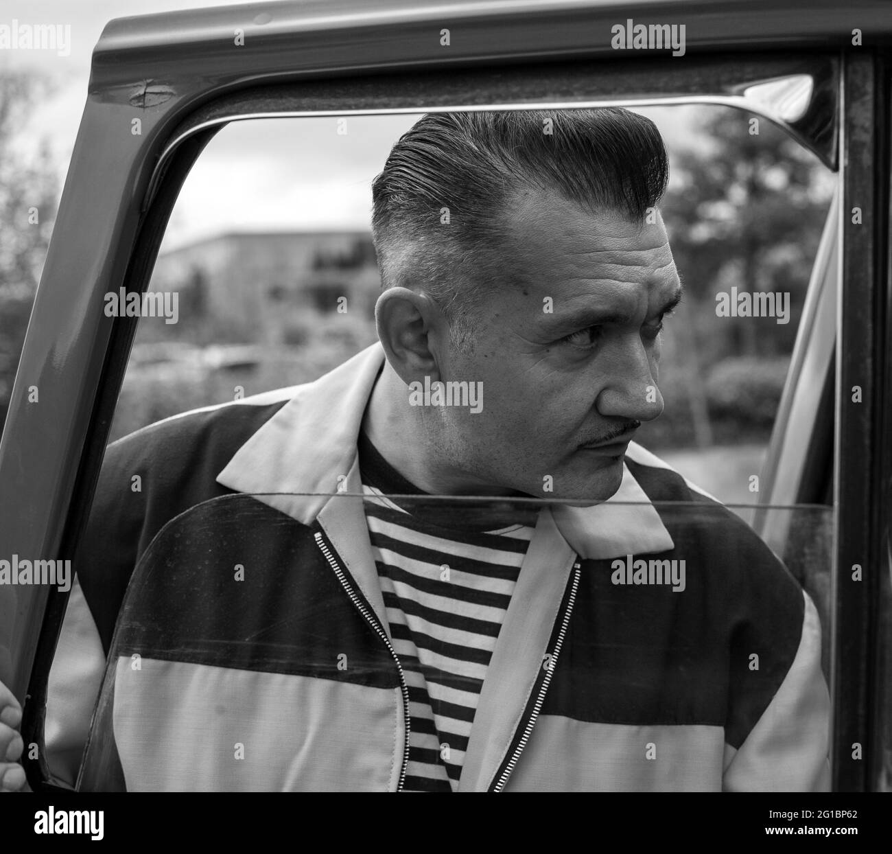 man portrait looking into classic vintage car. Man buying classic vintage car. Stock Photo