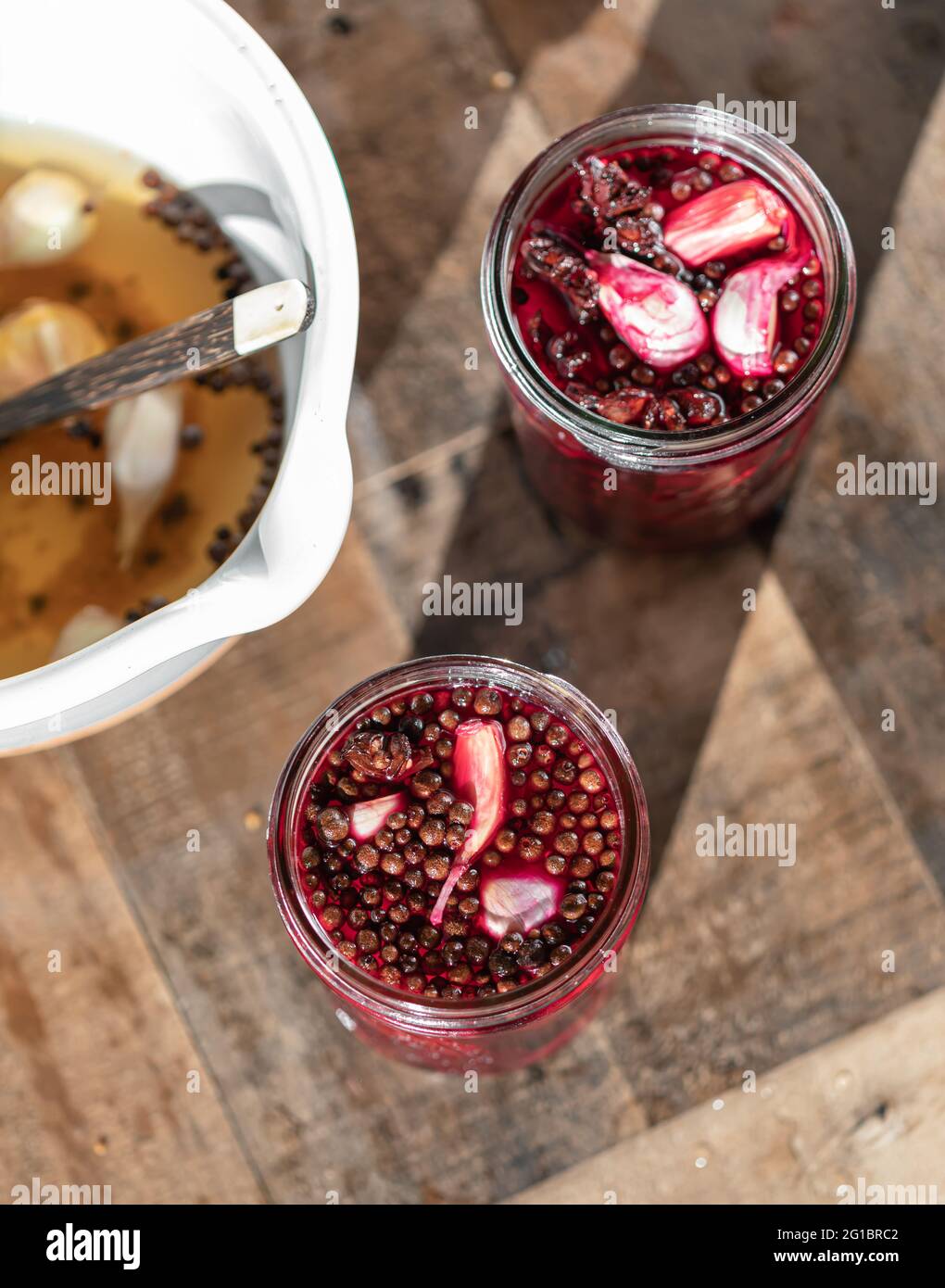 Pickles beets in brine with peppercorns and garlic. Rustic ambience, high contrast photography. Stock Photo