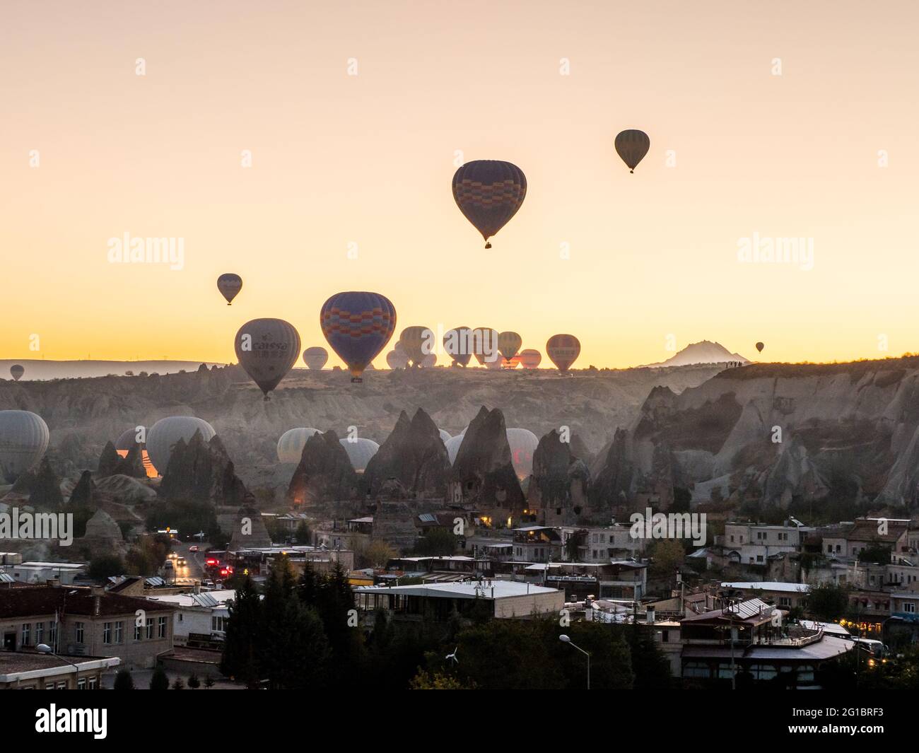 The hot air balloons flying over rocky mountains at scenic sunrise in ...