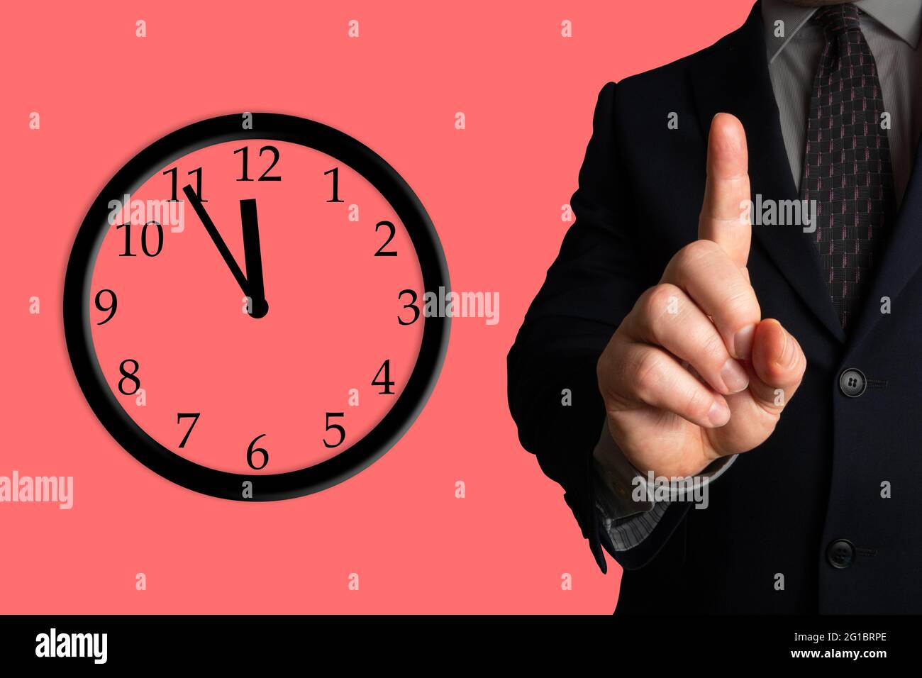 Manager raising his finger, pointing out that it's 5 minutes to 12. This symbolizes that it is high time to take action or call to action, attention. Stock Photo