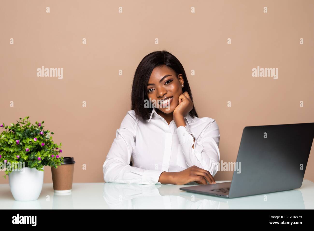 Smiling african businesswoman sitting in office working on laptop Stock ...