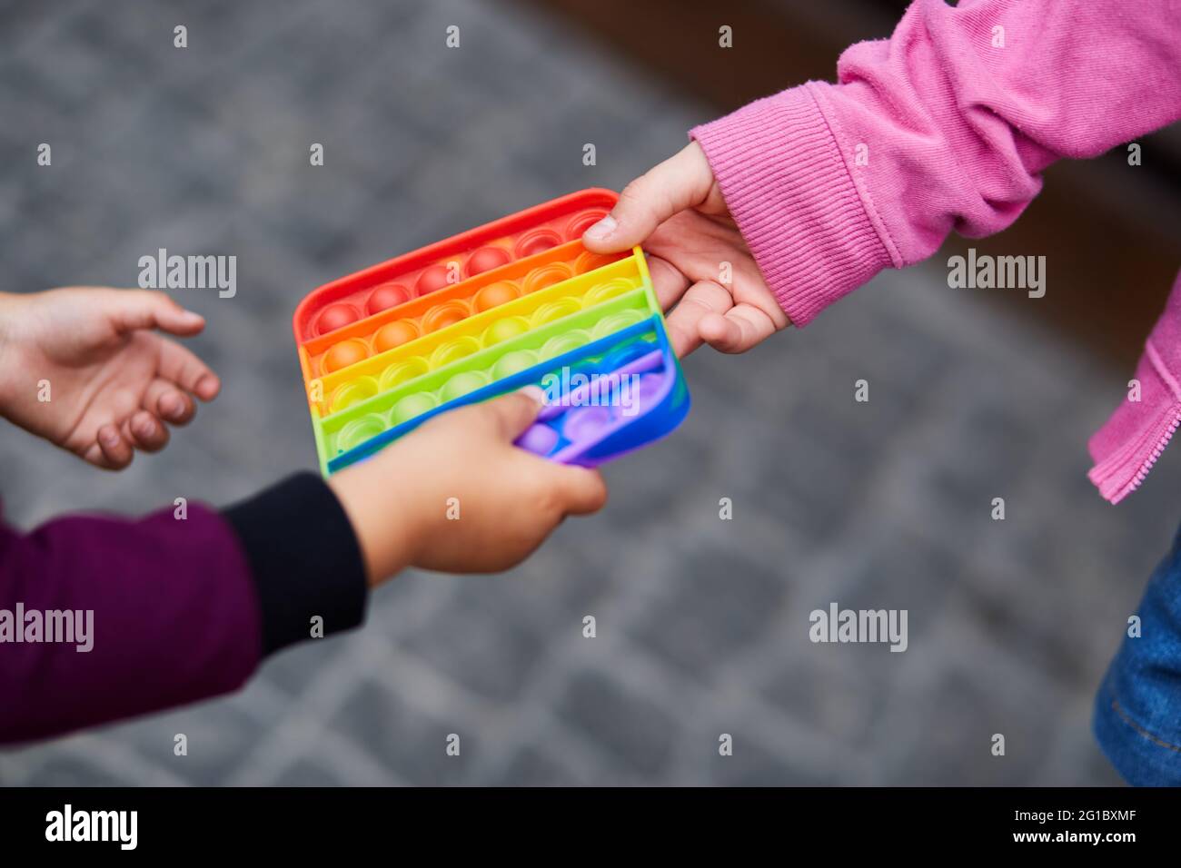 Rainbow sensory fidget. Colorful antistress sensory toy fidget push pop it in children's hands. Antistress trendy pop it toy. New trendy silicone toy. High quality photo Stock Photo