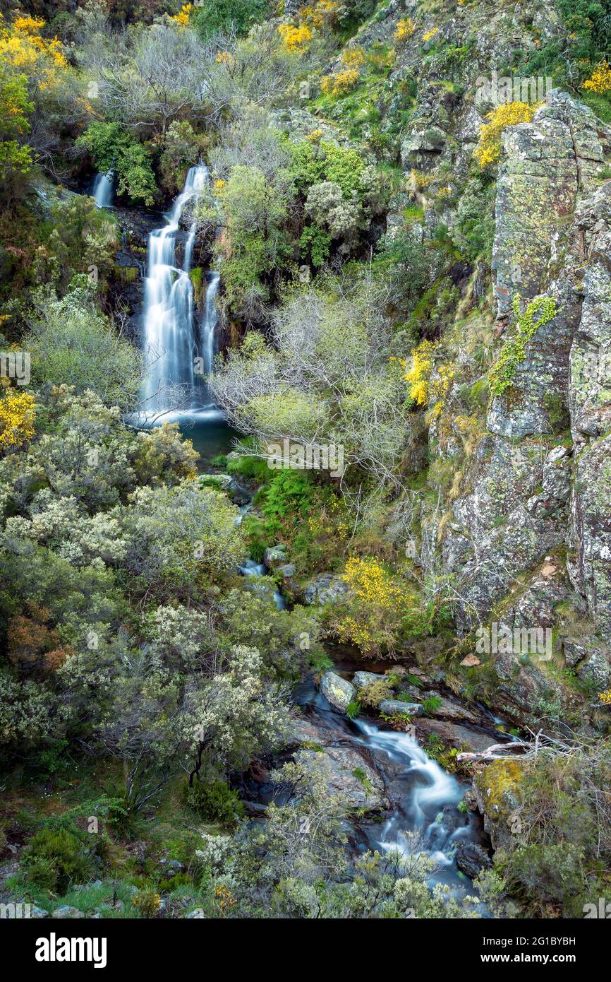 Beautiful waterfall of the Quelhas stream in the Serra da Lousã, in Portugal, in the middle of escarpments with vegetation with spring colors. Stock Photo