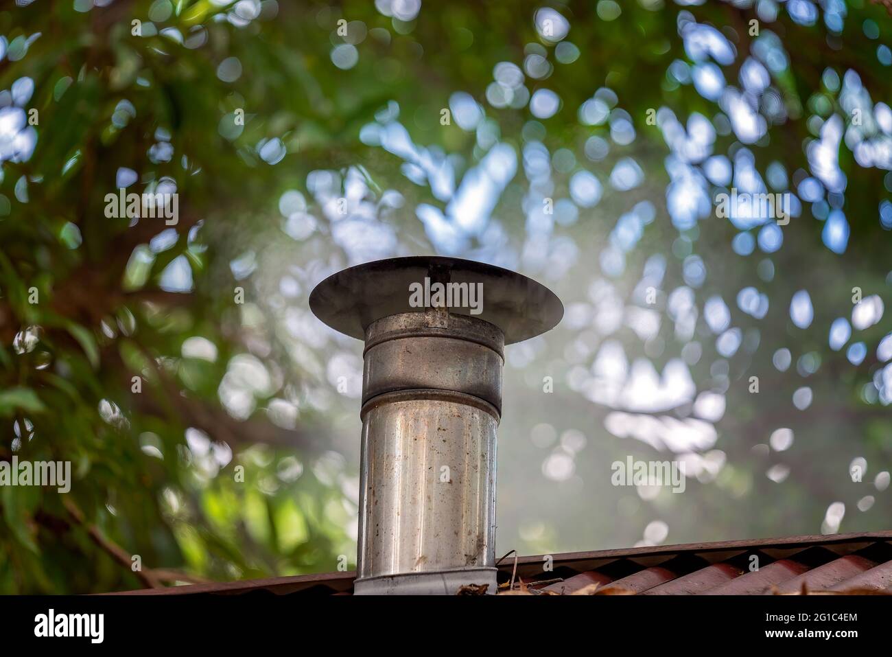 Steam emitted through the roof through the trees from the steel vent of