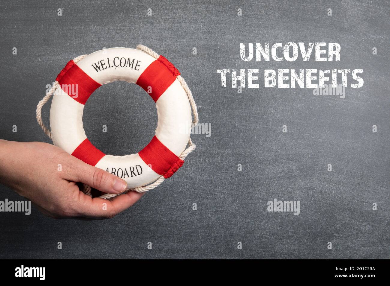 Uncover The Benefits. Black chalk board background. Stock Photo