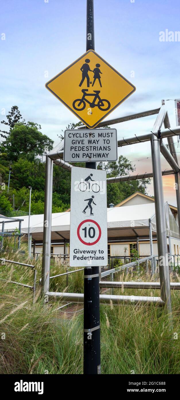 Signs indicating that cyclist must give way to pedestrians. Sunset environment Stock Photo