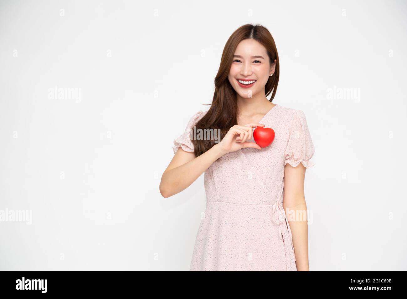 Attractive young Asian woman holding red love heart isolated on white ...