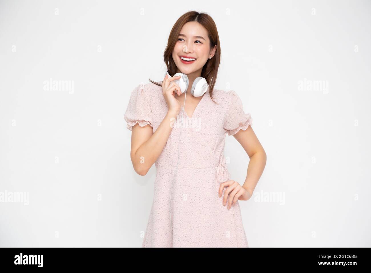 Young Asian woman listening music with headphones isolated on white ...