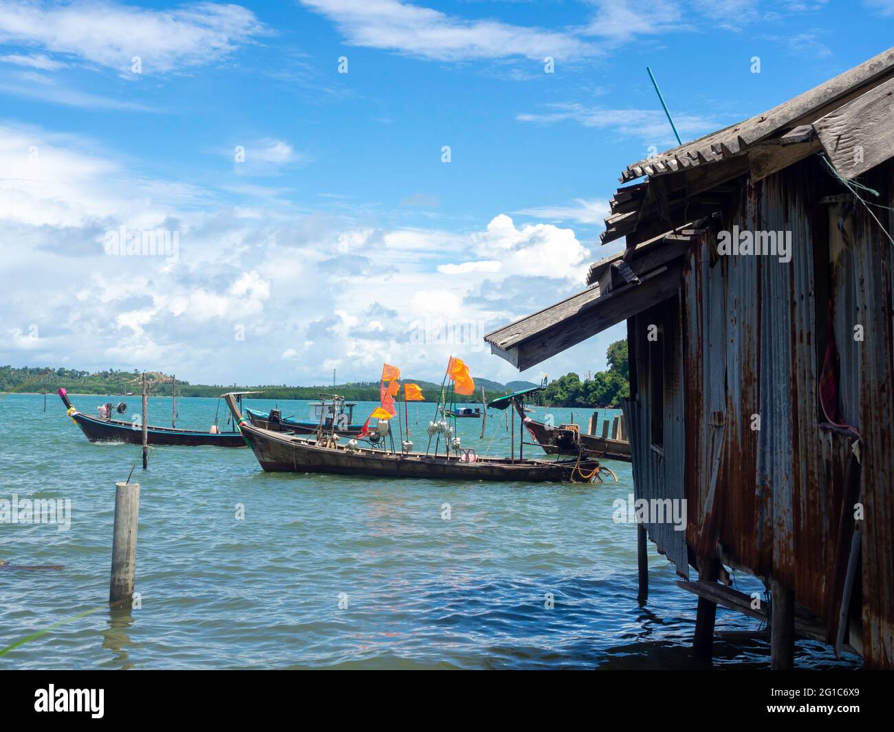 Beautiful seascape summer background. Fisherman house with many local longtail boat on the sea and sky background on a sunny day in Thailand. Stock Photo