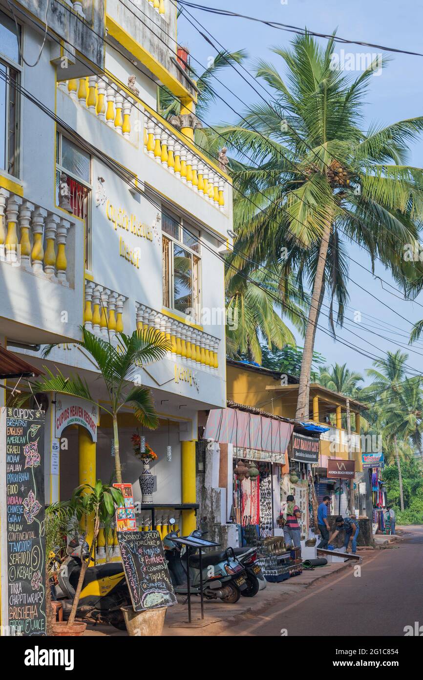 Colourful exterior of hotel with palm trees on main street, Agonda, Goa