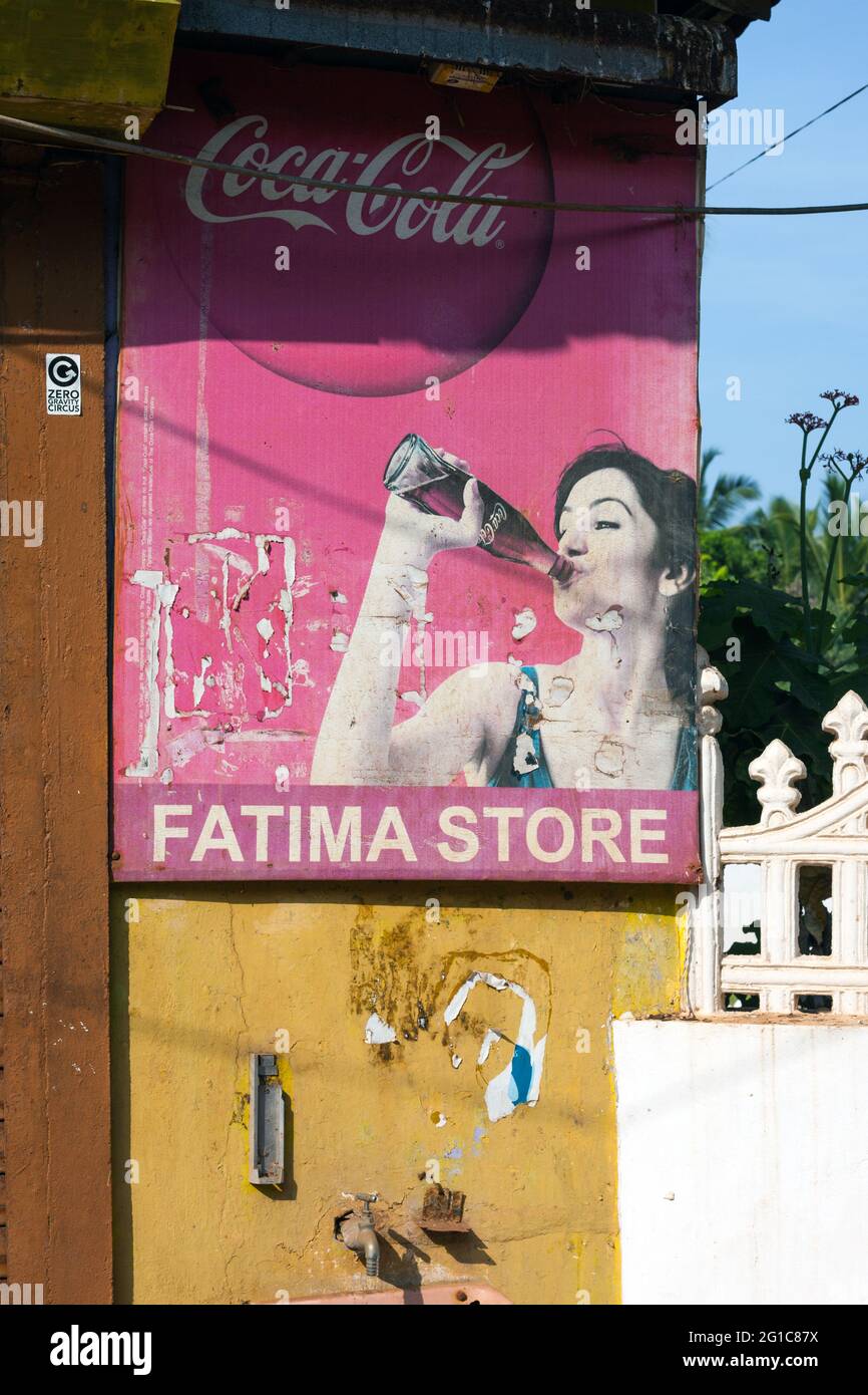 Retro graphic and image of female drinking Coca-Cola bottle displayed on  sign outside Fatima Store, Agonda, Goa, India Stock Photo - Alamy