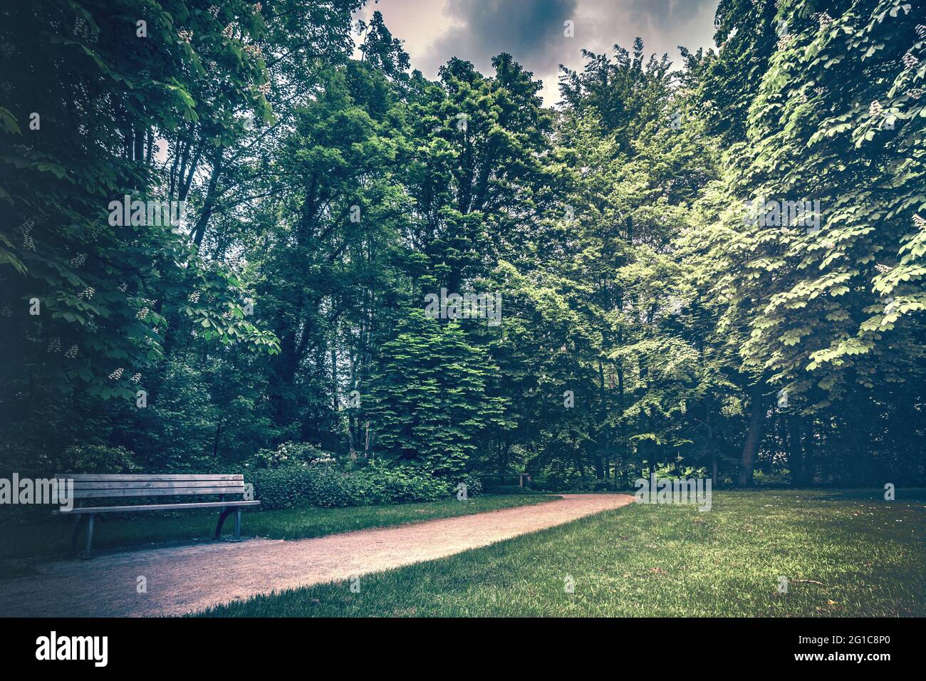 Parkanlage im schönen Schlosspark am Schloss Borbeck. Gehweg mit Sitzbank im Sommer bei saftig grünen Wiesen und Wäldern. Ruhrpott Ruhrgebiet. Stock Photo