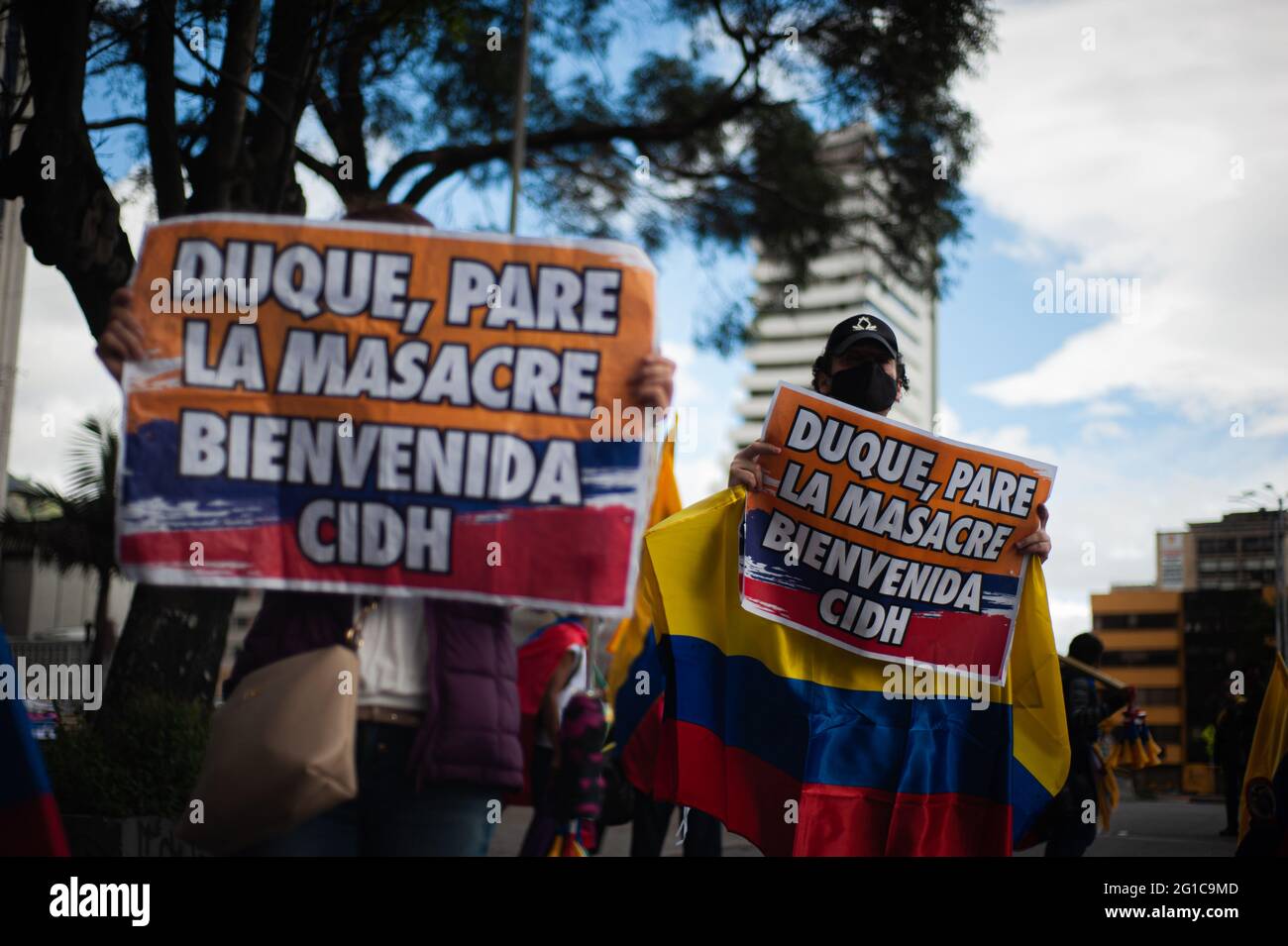 Bogota, Colombia. 06th June, 2021. Demonstrators hold signs that read 'Duque, stop the massacre, welcome the CIDH' as people and indigenous Misak community gather to wait for the arrival of the Inter-American Comission on Human Rights (CIDH) amid police brutality and unrest during anti-government protests that reach at least 70 dead in the past month of demonstrations, in Bogota, Colombia on June 6, 2021. Credit: Long Visual Press/Alamy Live News Stock Photo