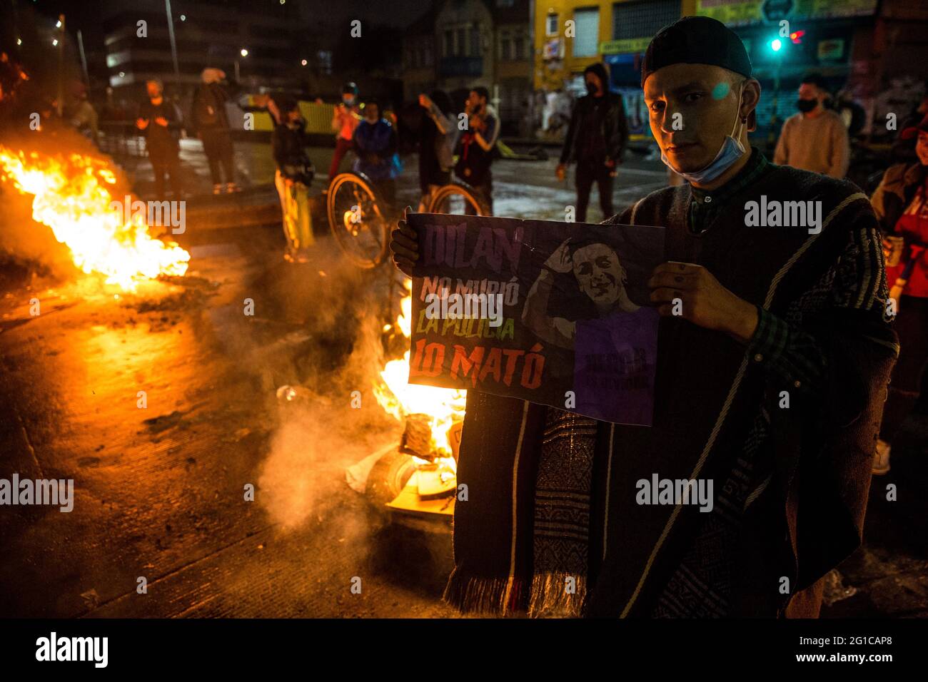 A protester holds a placard to commemorate the death of Dilan Cruz, a young boy who was killed by the police in 2019 during the demonstration.On the 28th of May, a month after the national strike first began, protesters continue to demonstrate on the streets of the Columbian capital Bogotá and all over the country to oppose government policies. Multiple demonstrations and marches took places during the day, with thousands of people participating in the strike. At Plaza de Los Heroes (Heros Square), one of the main demonstration zones in Bogotá, more than 4.000 people gathered, to watch concer Stock Photo