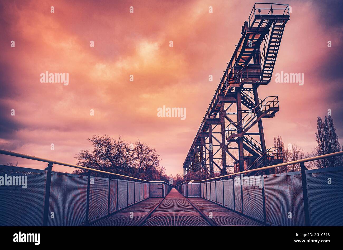 Metal and steel promenade on the Emscher in central perspective. Duisburg Landscape Park. Industrial machines and rusted components in the Ruhr area. Stock Photo