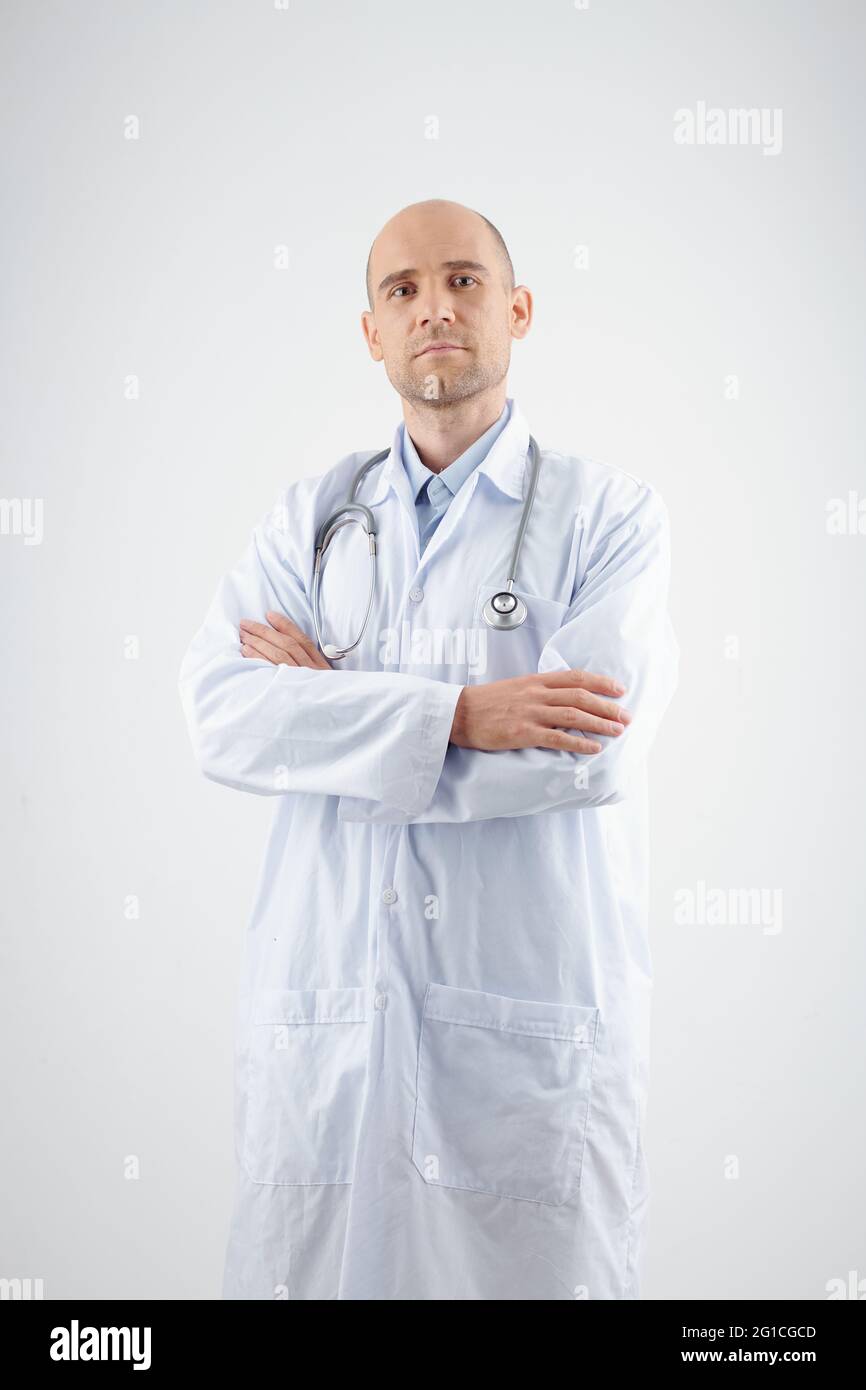 Studio portrait of confident experienced general practitioner crossing arms and looking at camera Stock Photo