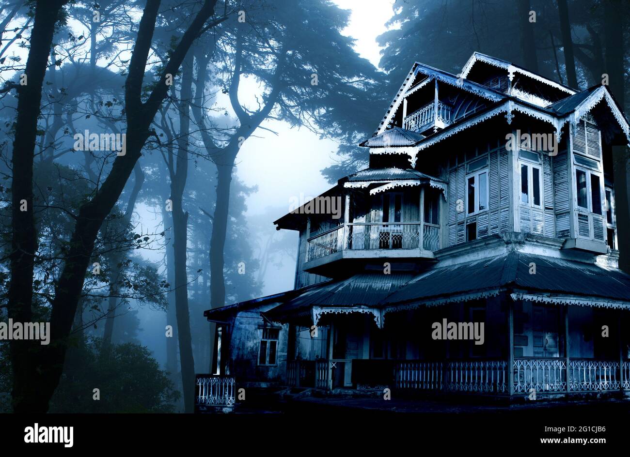 Horizontal Halloween banner with haunted house. Old abandoned house in the night forest. Scary colonial cottage in mysterious forestland. Photo toned Stock Photo