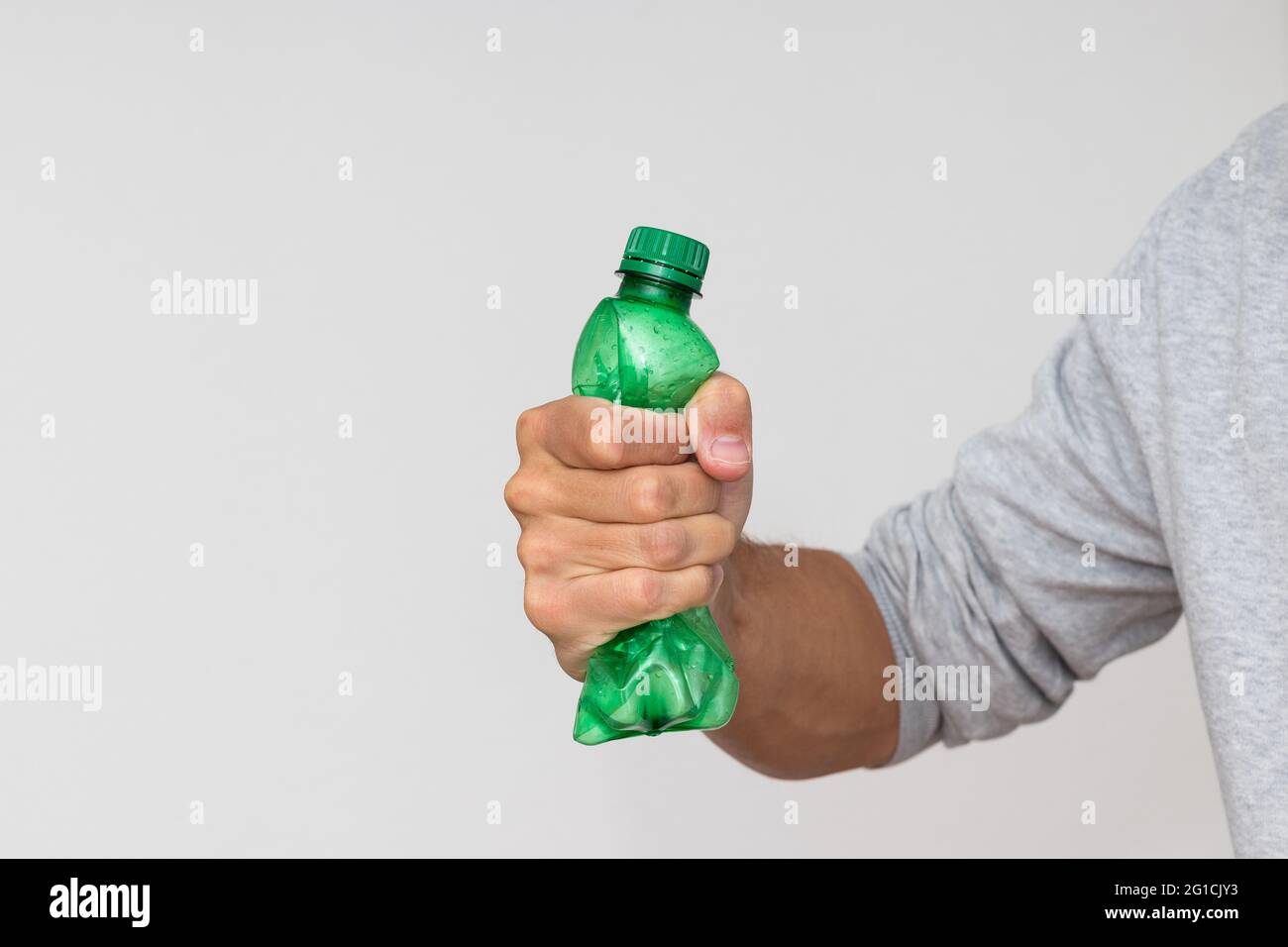 Plastic bottle recycling or pollution concept. Hand squeezing or