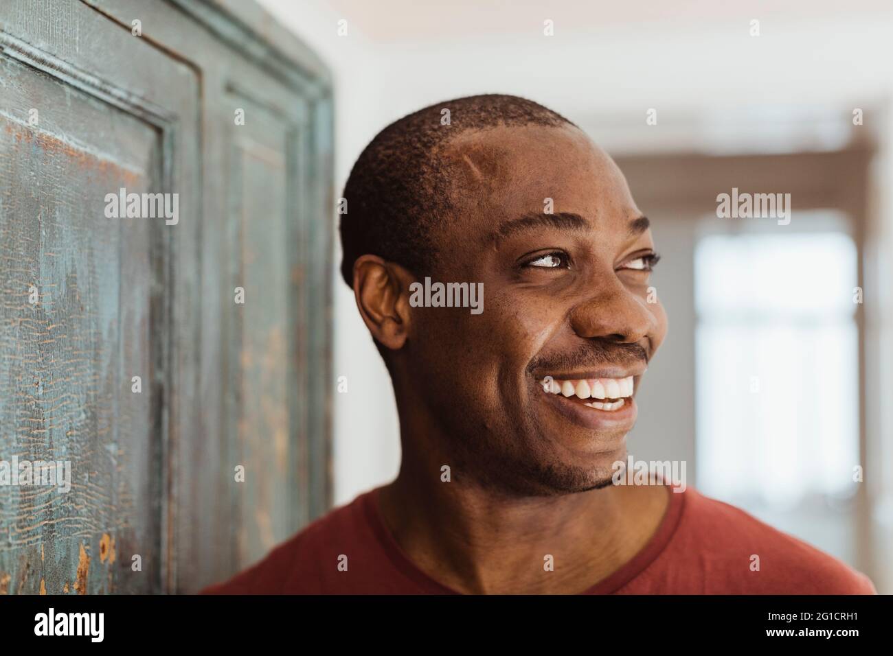 Happy man looking away at home Stock Photo