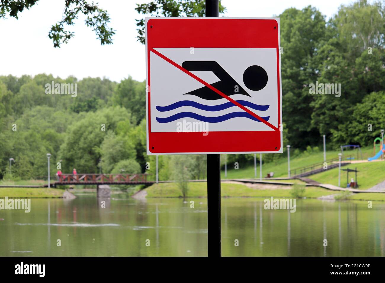 No swimming sign on background of summer lake. Beach holiday in city park Stock Photo