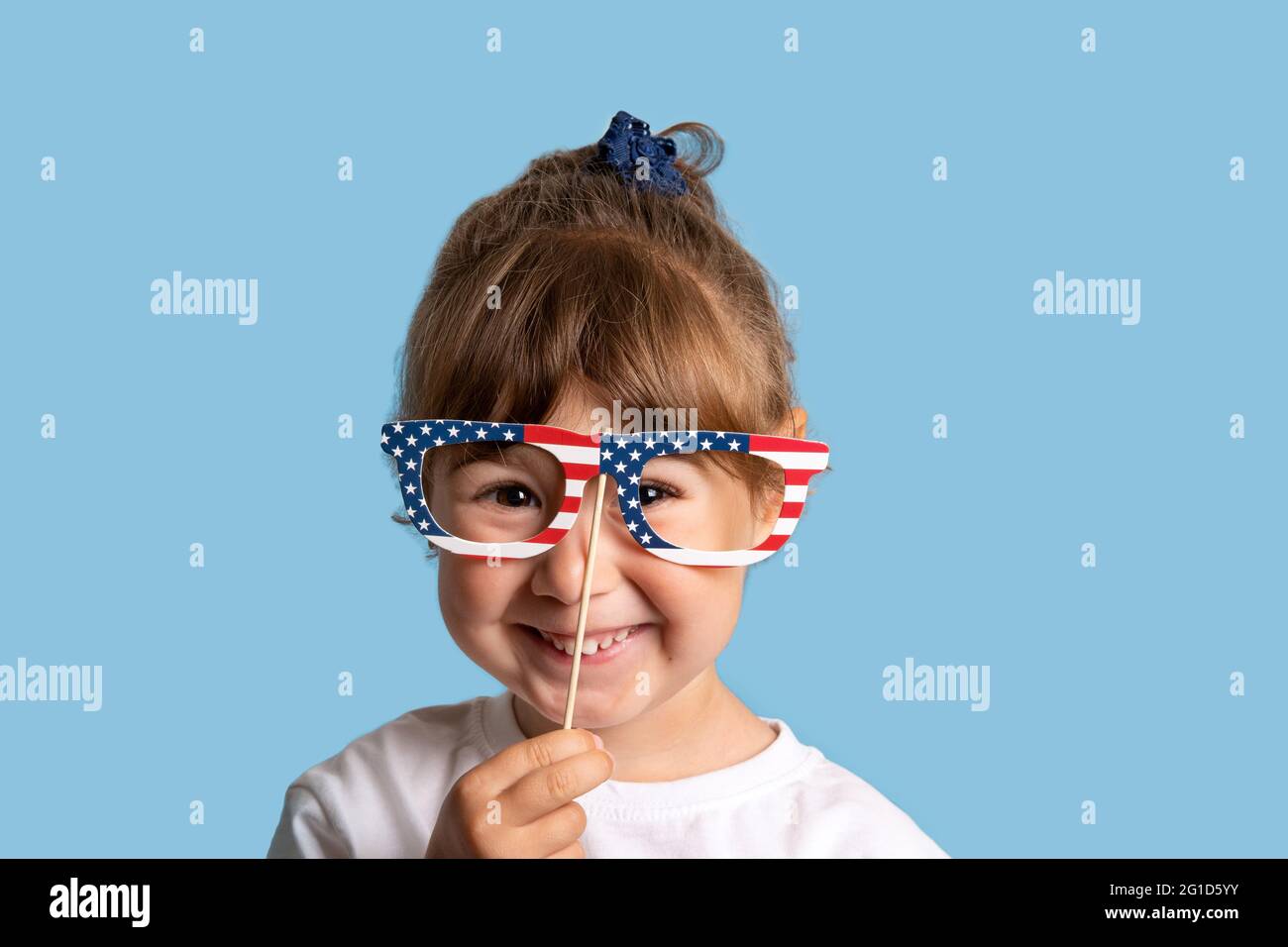 Baby girl smiling with USA flag glasses on blue background Stock Photo Alamy