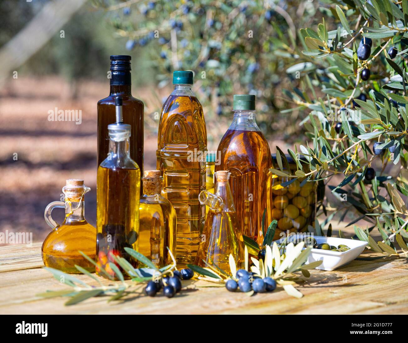 Olive oil on wooden table on background of olive tree Stock Photo Alamy
