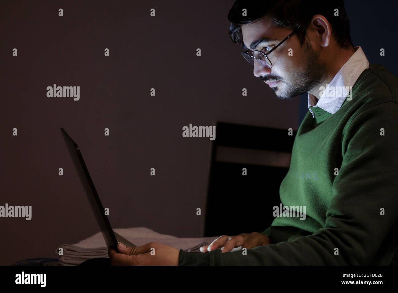 A young handsome indian boy working on laptop. Stock Photo