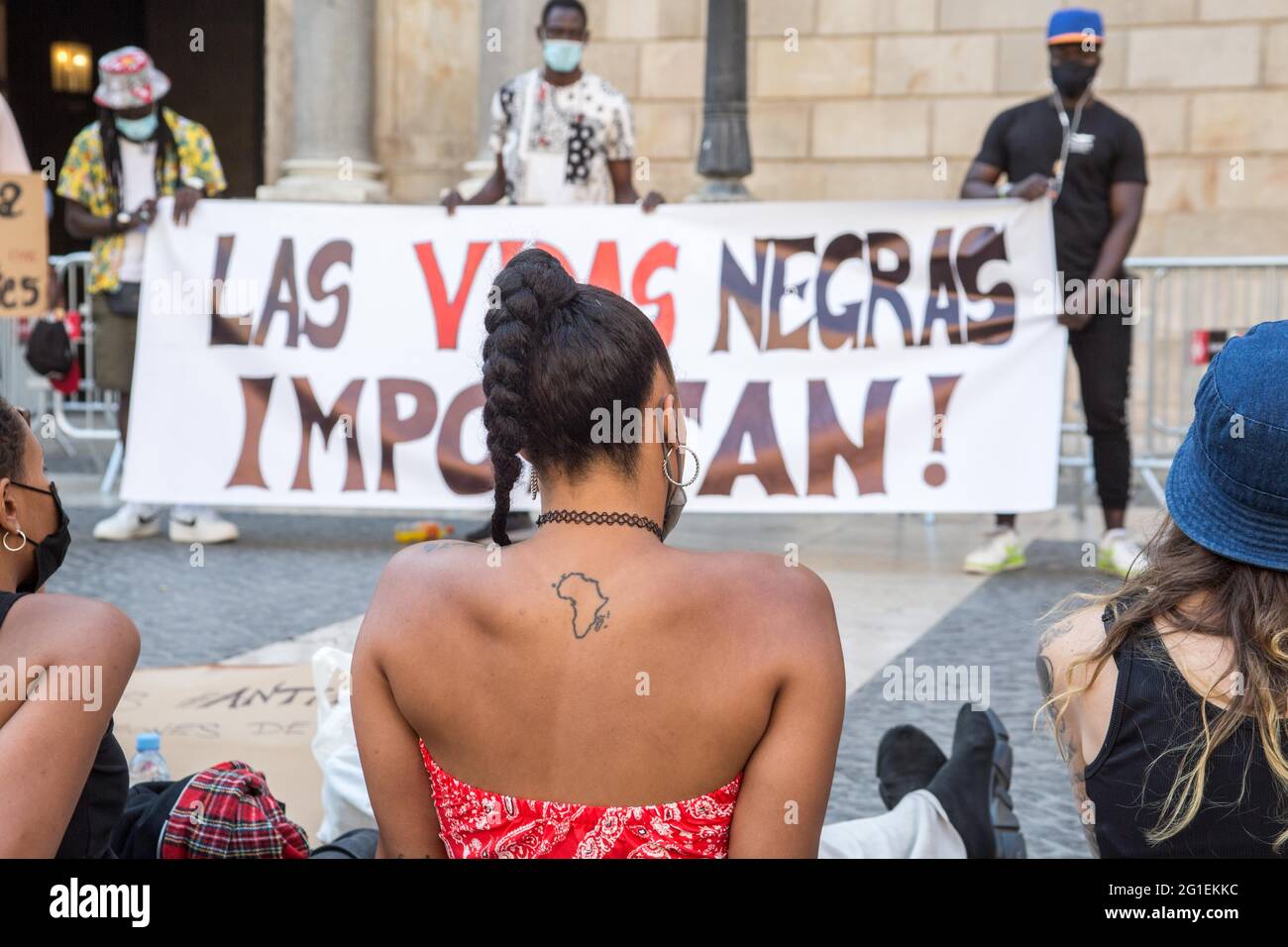 Barcelona, Spain. 06th June, 2021. A protester with a tattoo of the African continent is seen in front of a banner that reads, Black Lives Matter, during the demonstration.A little more than a year after the murder of George Floyd, in the United States that generated demonstrations in various cities of the world, groups of black activists from Barcelona have met, to reinforce the anti-racist struggle and the Spanish Black Lives Matter movement that has been created after the demonstrations of last year. Credit: SOPA Images Limited/Alamy Live News Stock Photo