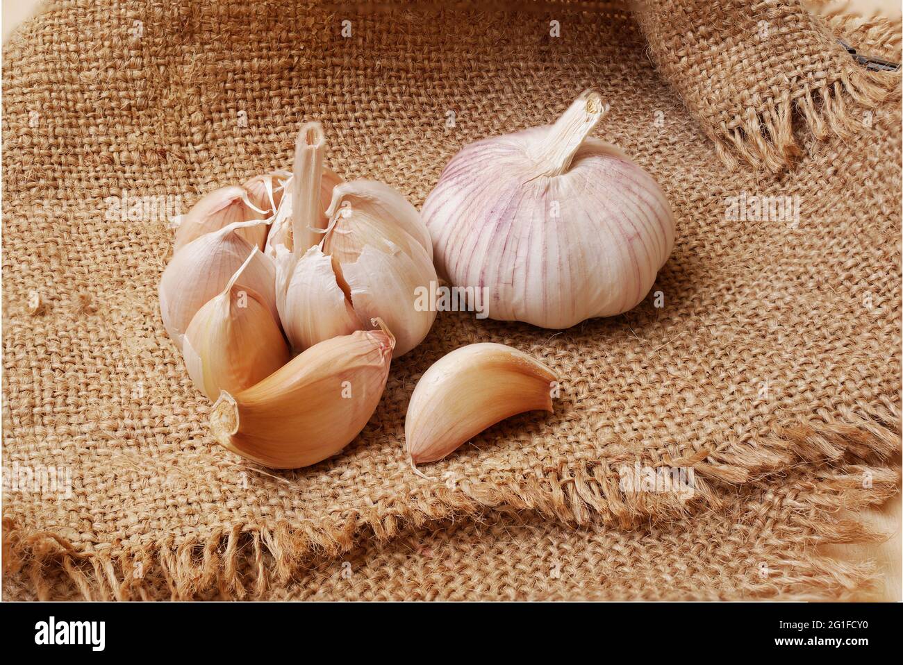 garlic bulb and cloves on sackcloth, full depth of field Stock Photo